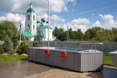 Наземный каркасный бассейн с лестницей и металлическими поручнями на открытом воздухе